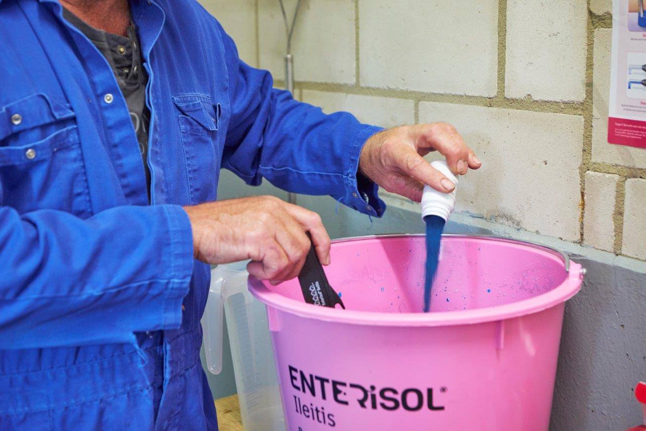 Na het water voegt Peter de blauwe kleurstof toe. Dit poeder maakt de vaccinatie visueel.