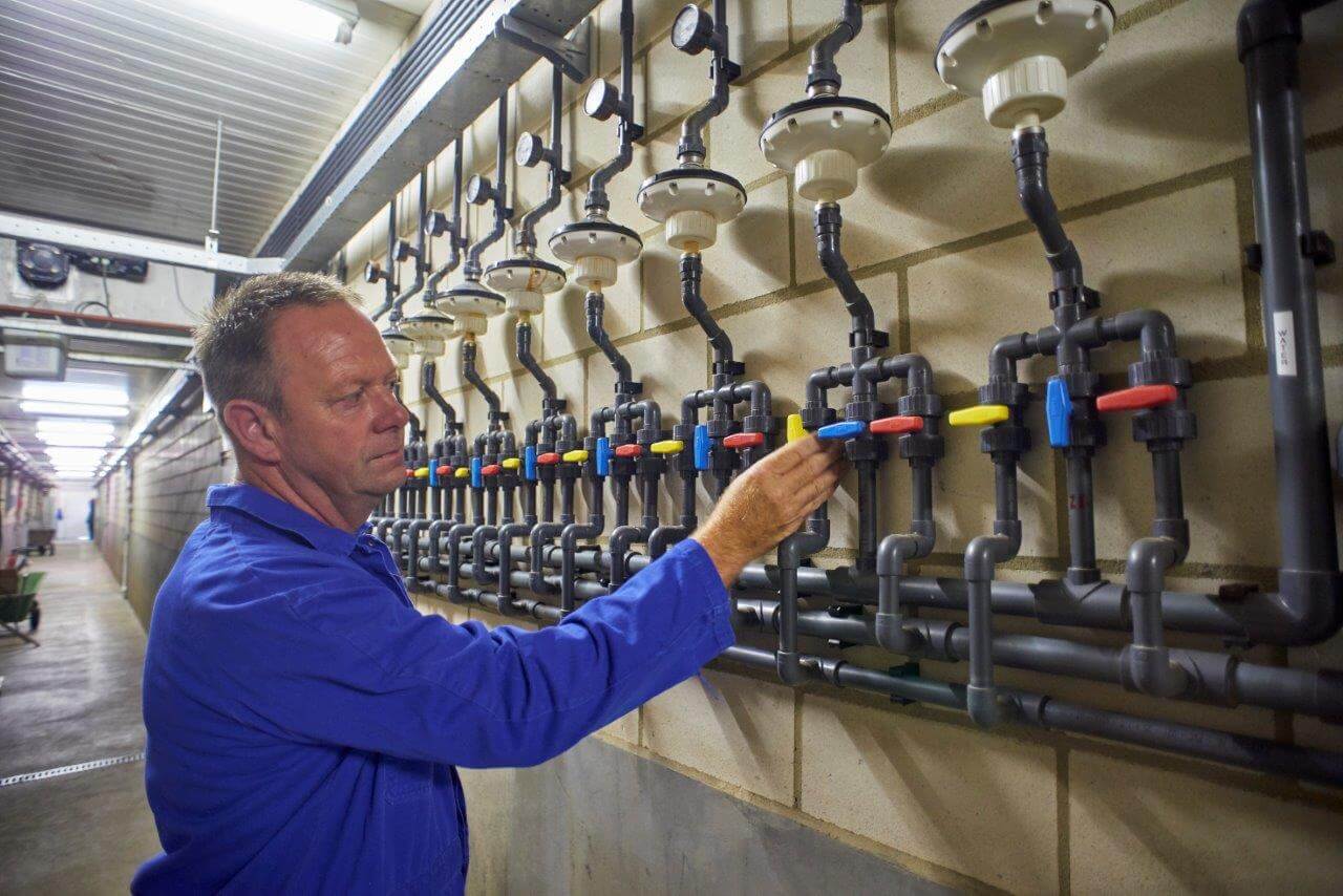 De blauwe afsluiter is al dicht gedraaid. Nu opent hij de gele klep waardoor de entvloeistof de komende uren naar de te behandelen afdeling kan stromen.