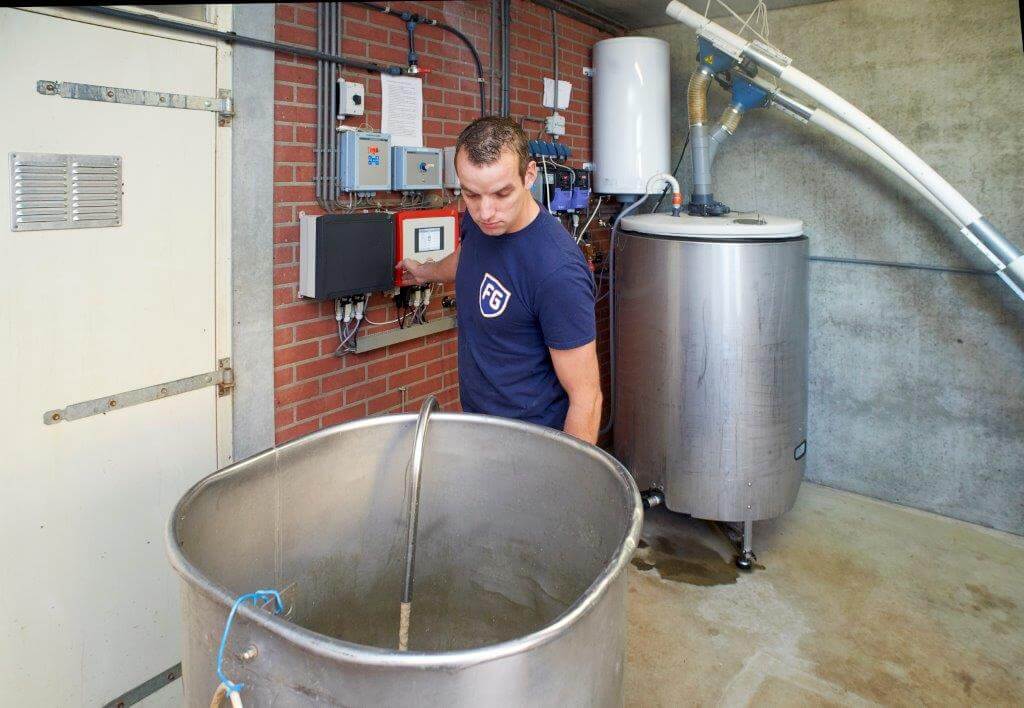 Willems ziet dat de schone voerketel weer gevuld wordt met de darmgezondheid bevorderende kant-en-klare brij met ferment.