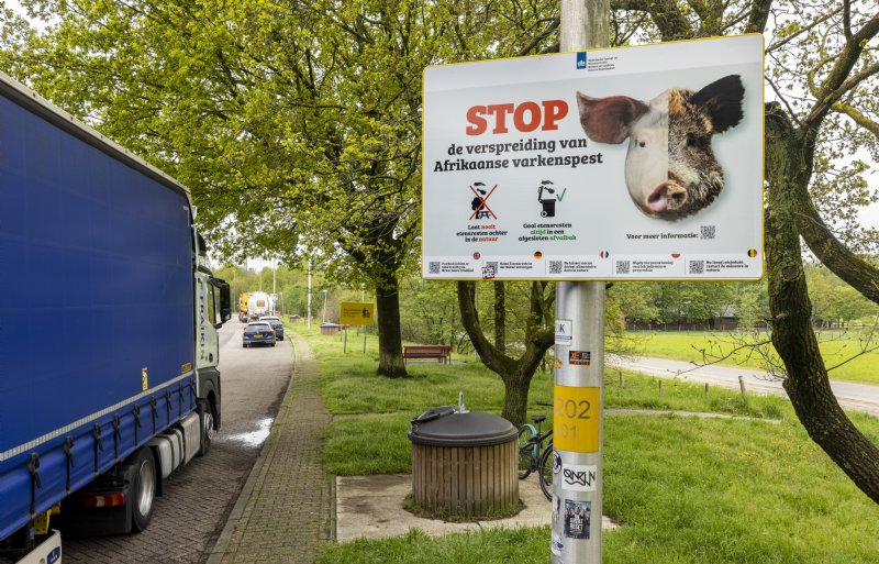 Nieuw bord 'Stop varkenspest' op een parkeerplaats.