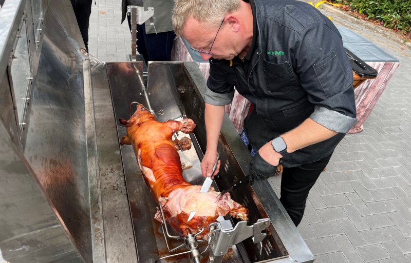 Een krokante big aan het spit van Pigarné wordt door een cateraar aangesneden en uitgeserveerd aan de bezoekers van de open dag.