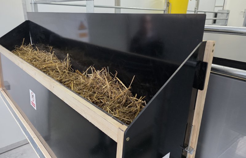 Vanuit de voorraadbak komt steeds weer vers stro op het schone deel van de vloer terecht.